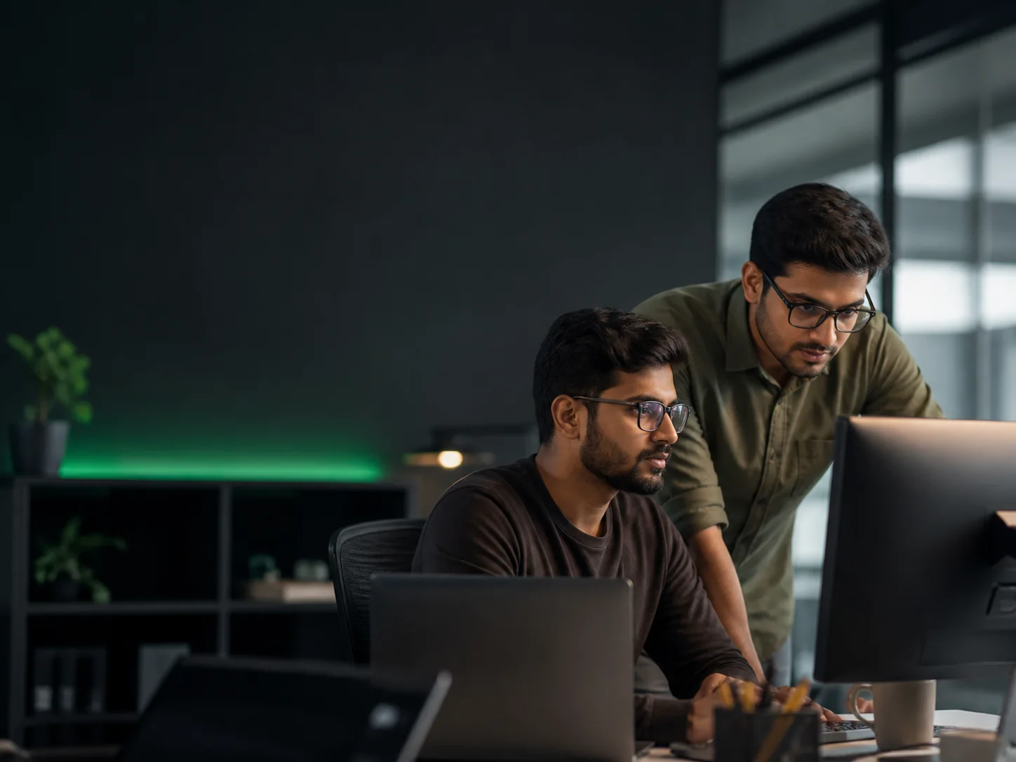 Two software engineers collaborating at a shared workstation